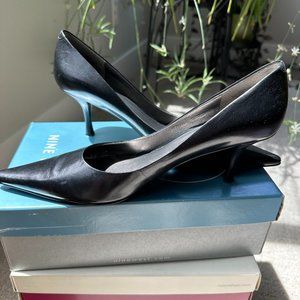 Black leather pointed toed pumps
